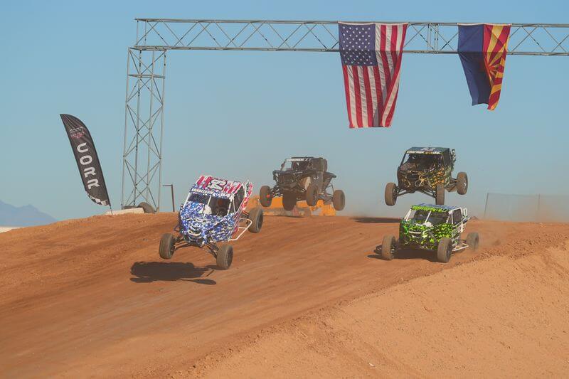 Pack of SxS jumping under the American and Arizona flags